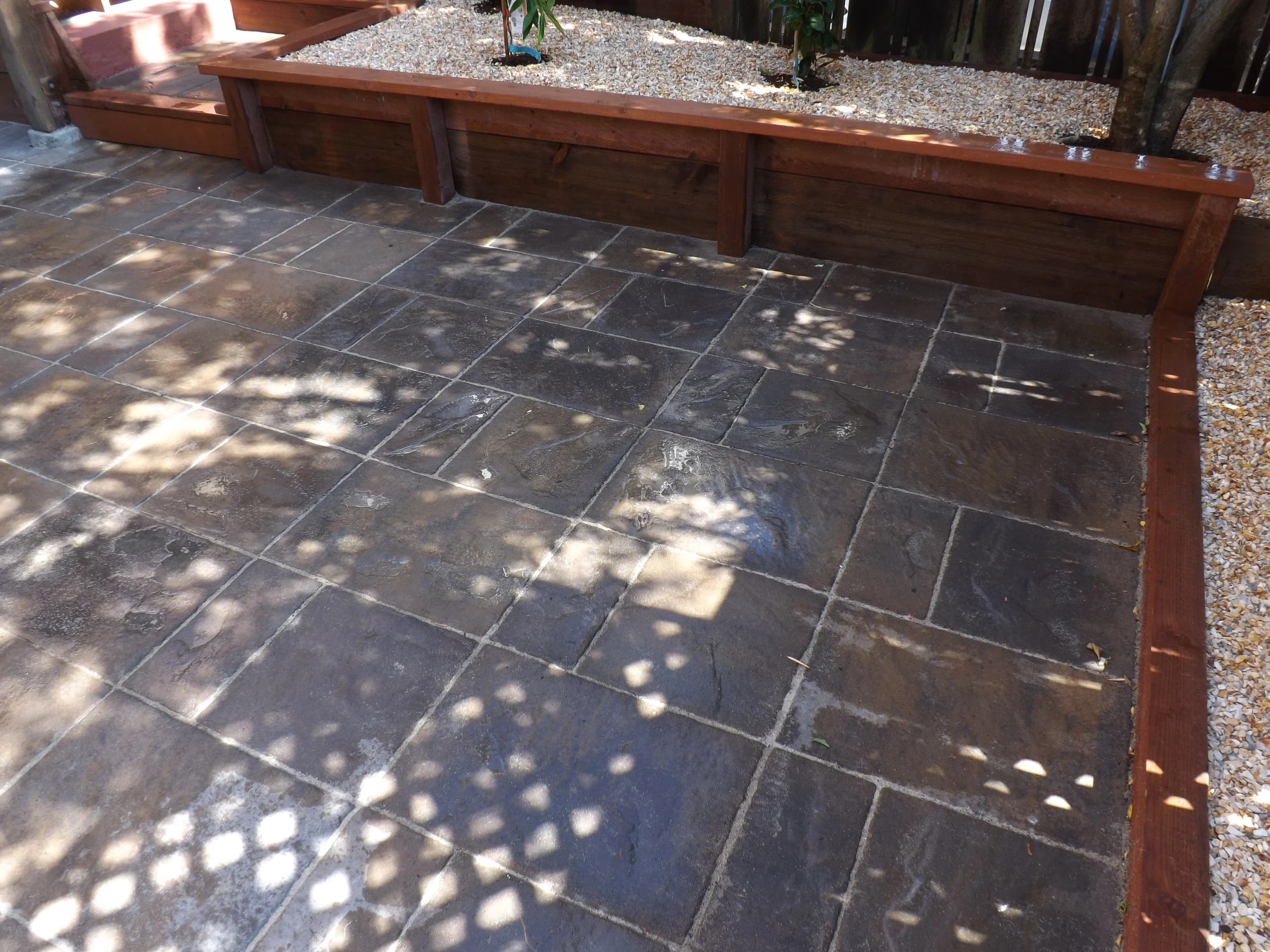Patio with tile slab and miniature rock bed in perimeter in Oakland.
